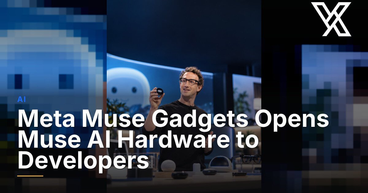 A man holds a small device while standing behind a table displaying various electronic gadgets.